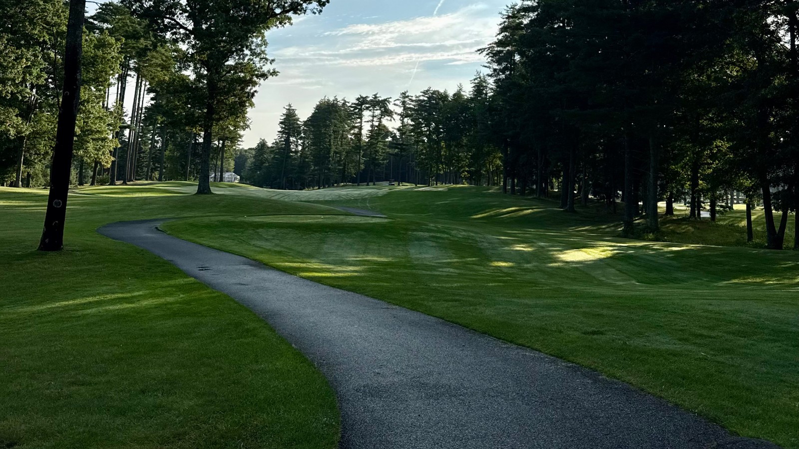 Cart path curving along a tree-lined fairway in morning light at Butter Brook Golf Club in Westford, MA