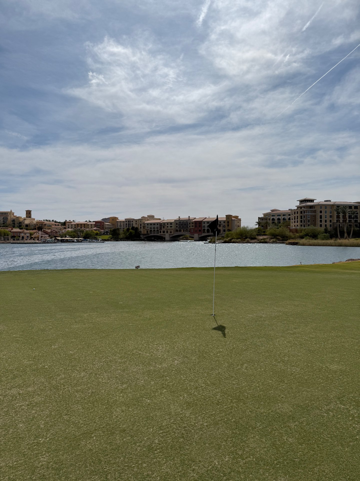 Green beside Lake Las Vegas at Reflection Bay Golf Club with the Mediterranean-style village across the water