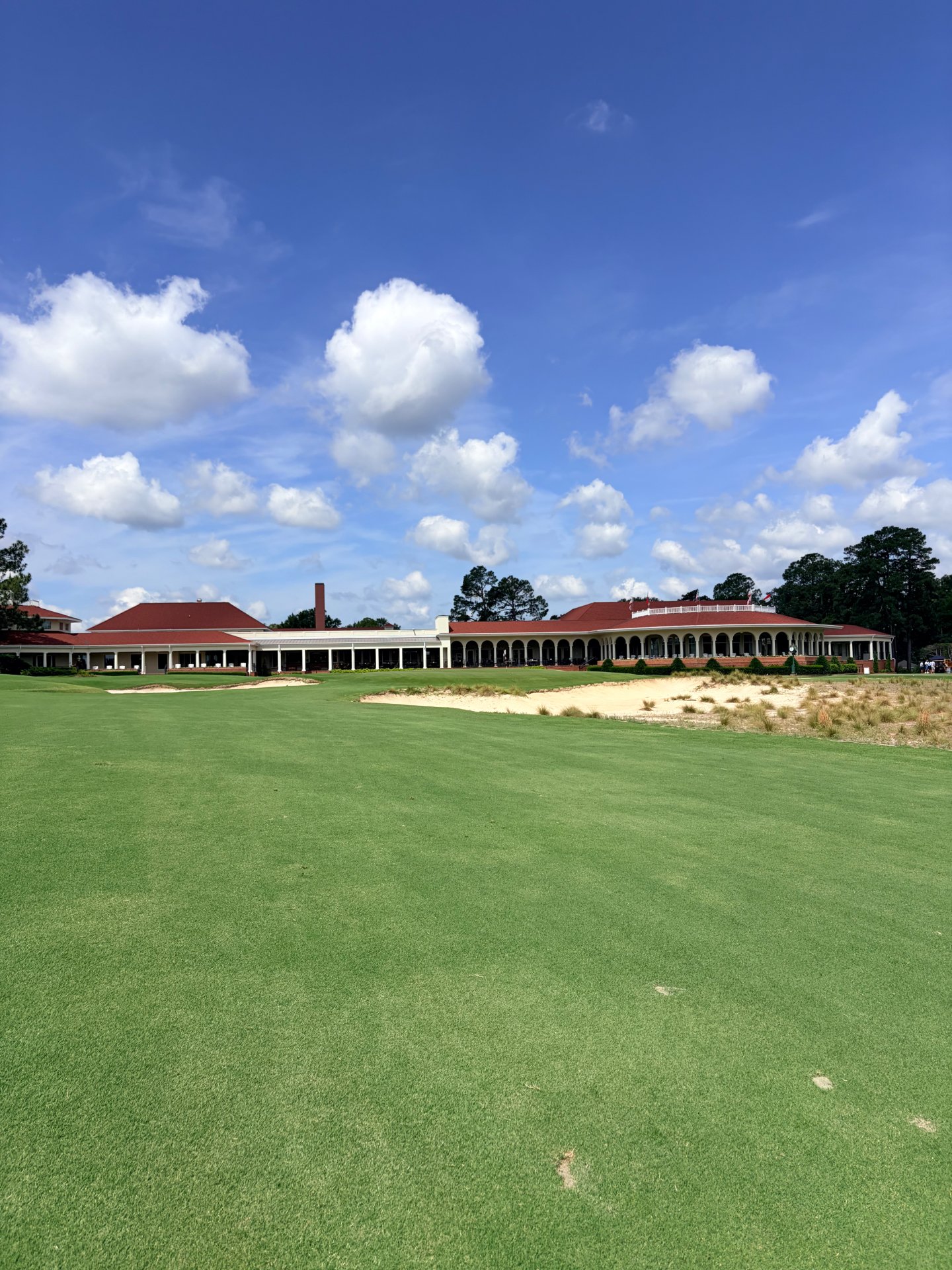 Approach up the closing fairway toward the clubhouse and sandy waste bunkers at Pinehurst No. 2 in Pinehurst, North Carolina