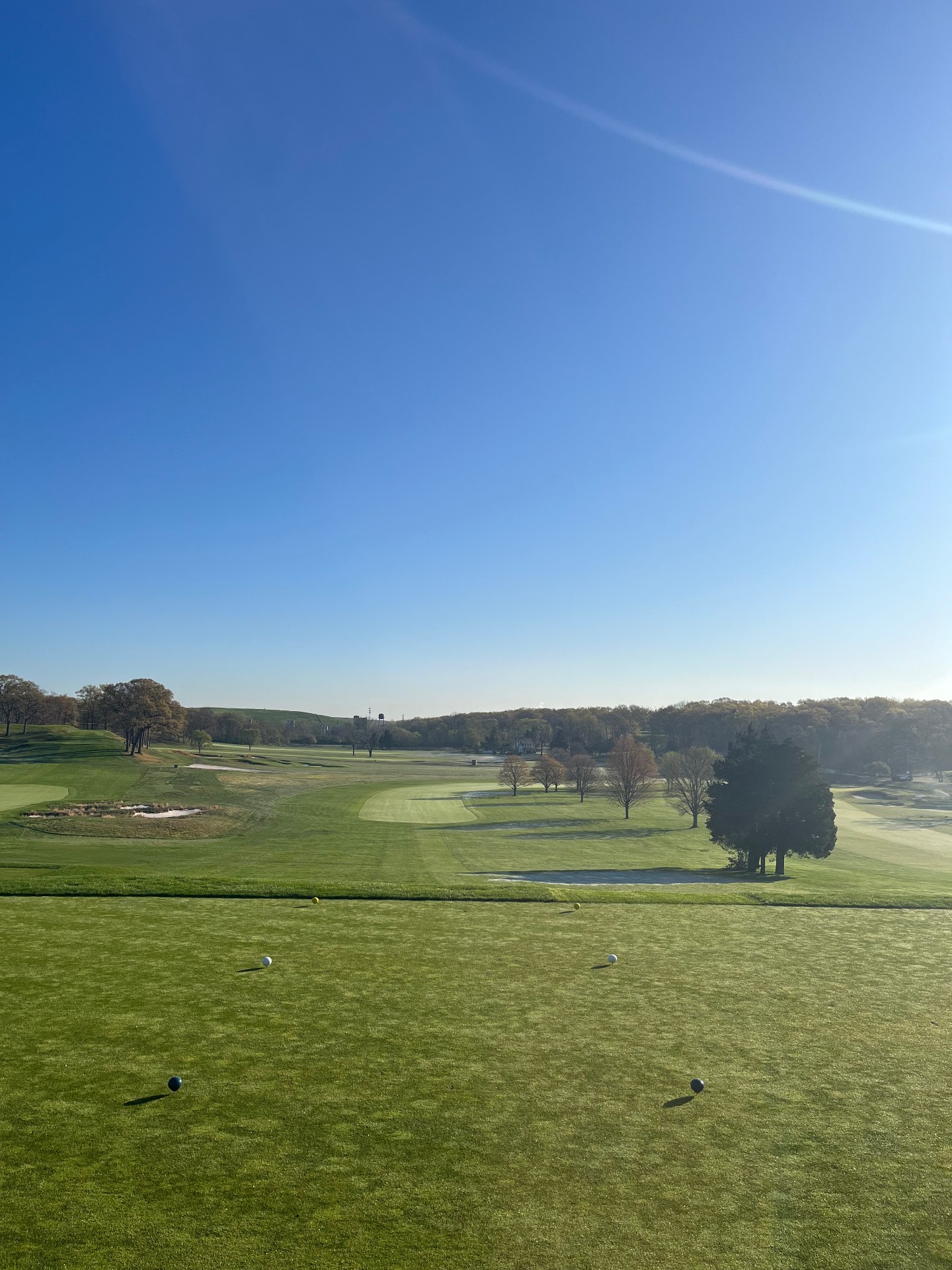 View from an elevated tee at Bethpage State Park Black Course, Farmingdale NY, with wide fairways and bunkering under clear blue sky