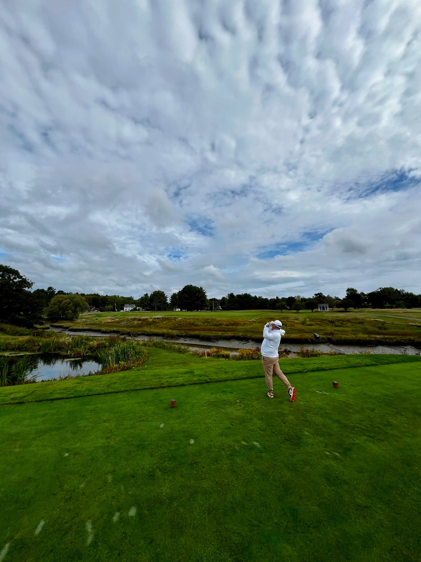 Golfer teeing off over tidal marsh at Cape Arundel Golf Club in Kennebunkport, Maine