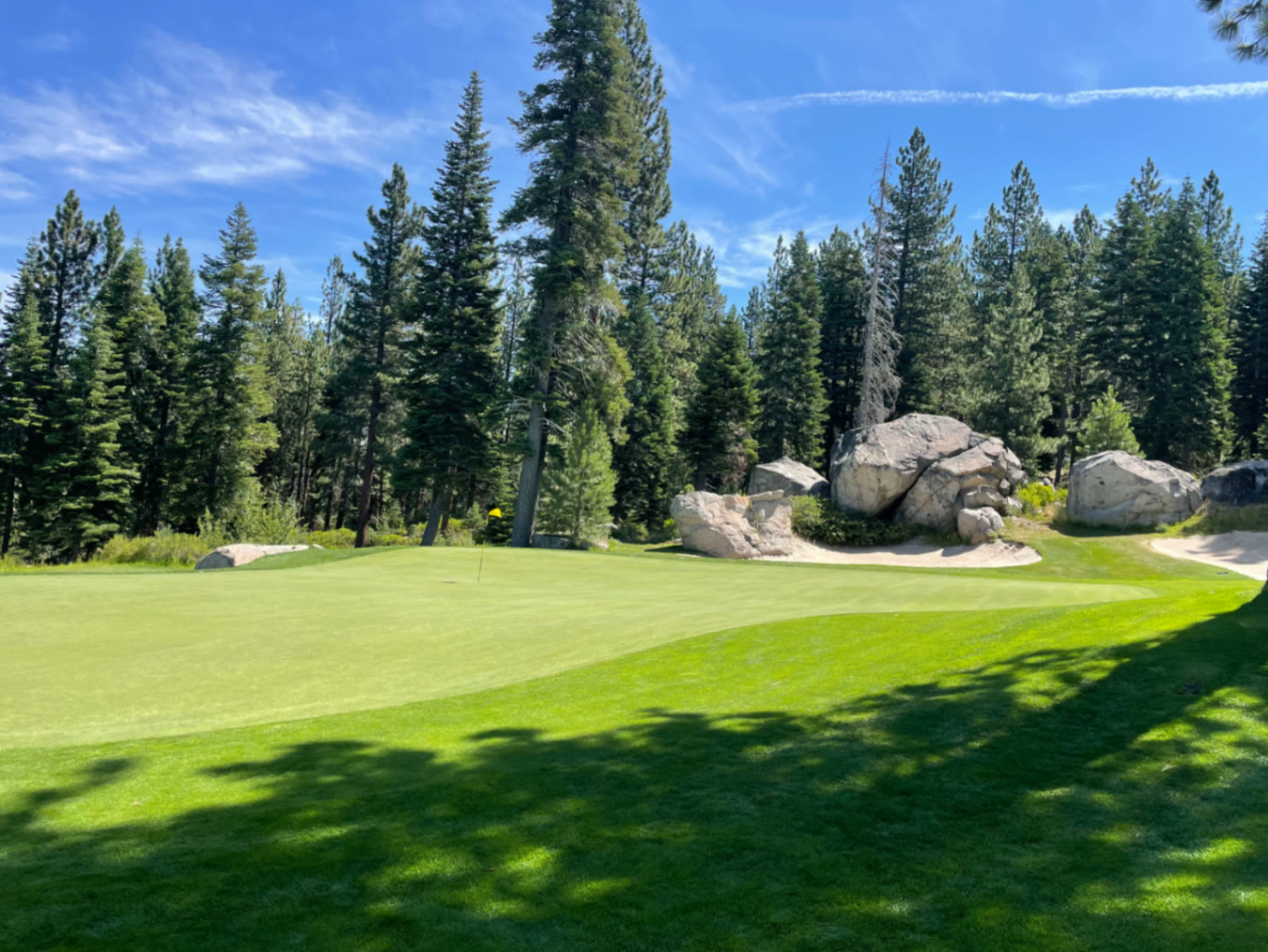 Green framed by granite boulders and tall pines at Coyote Moon Golf Course in Truckee, California